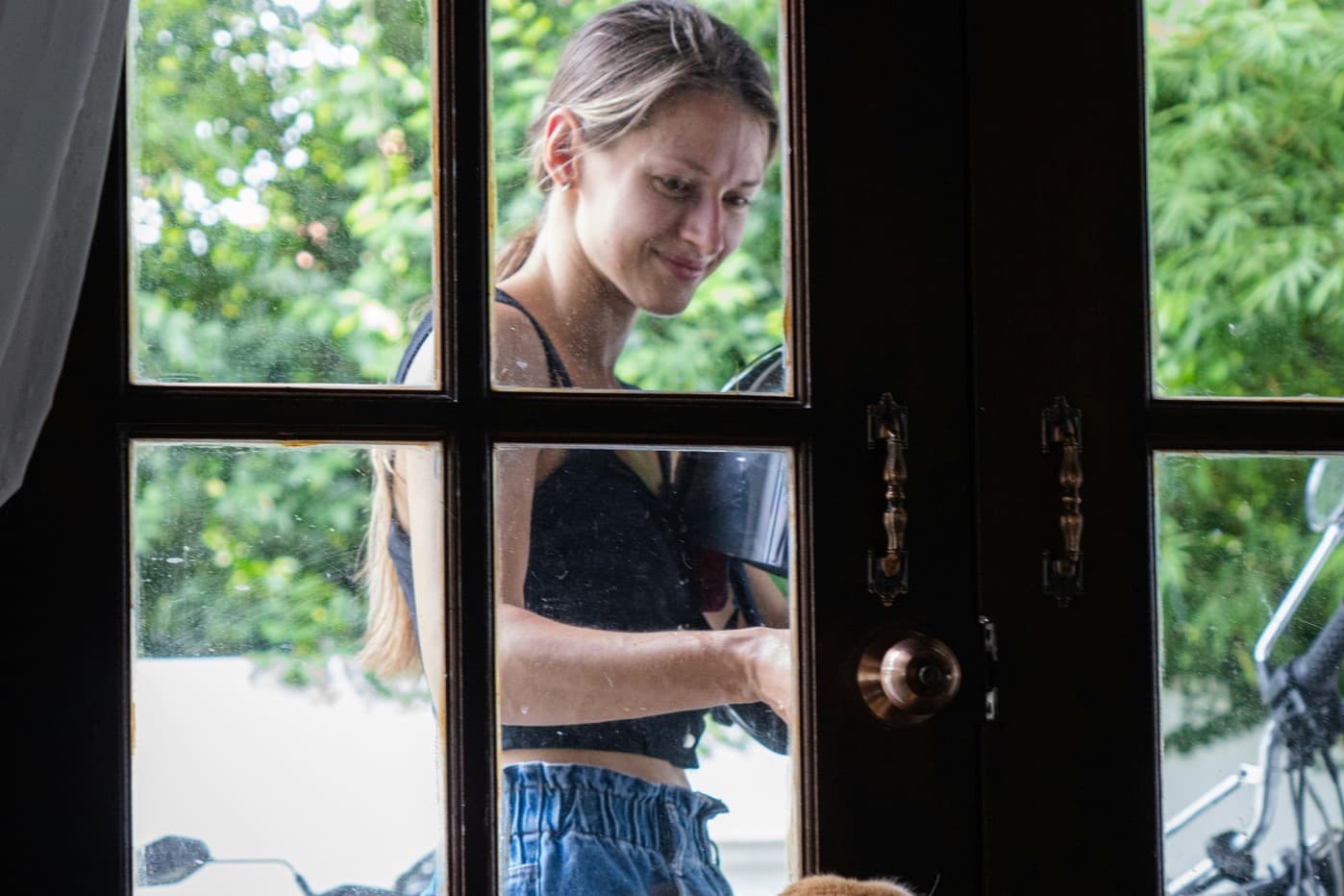 A sitter arriving at a client's front door while the family dog watches